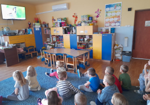 Dzieci oglądają film edukacyjny o wróblach.